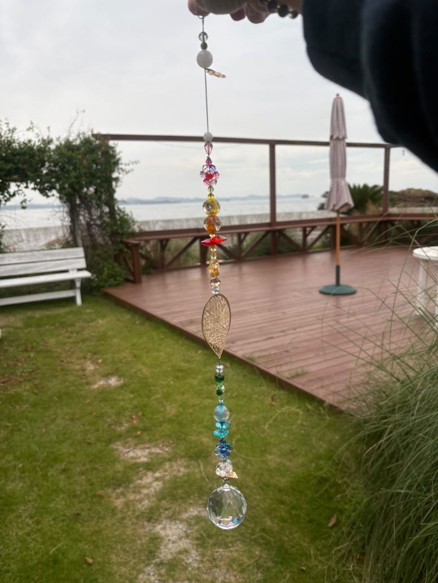 海を望む庭で、手に持って掲げたサンキャッチャー